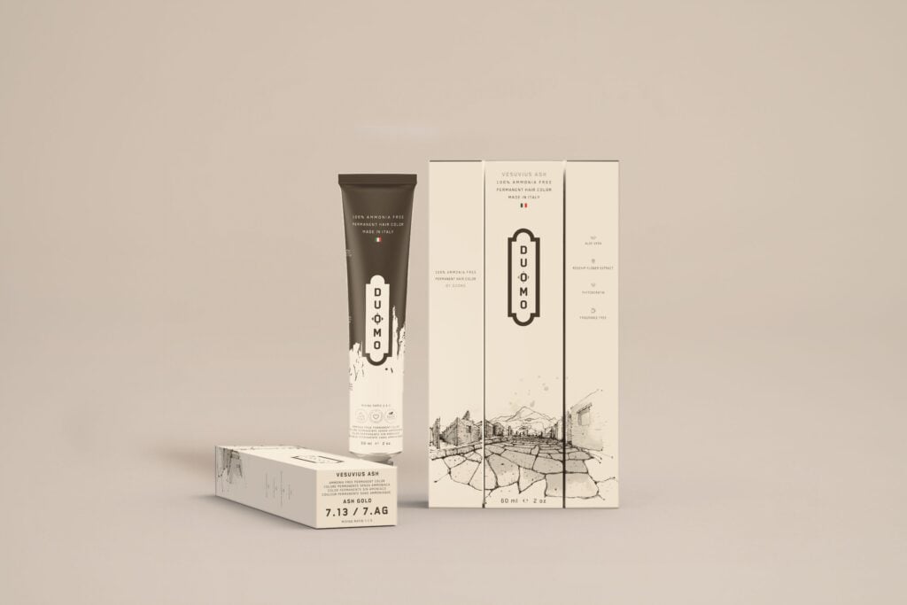 Duomo 7.13 / 7AG - Vesuvius Ash - Ash Gold hair color tube and boxes on a beige backdrop
