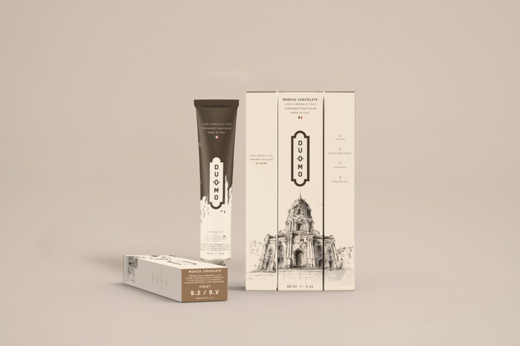 Duomo 9.2 / 9V - Modica Chocolate - Violet hair color tube and boxes on a beige backdrop