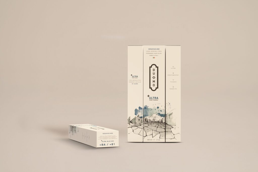 Duomo BA+ Ultra Blue Ash hair color tube and boxes on a beige backdrop