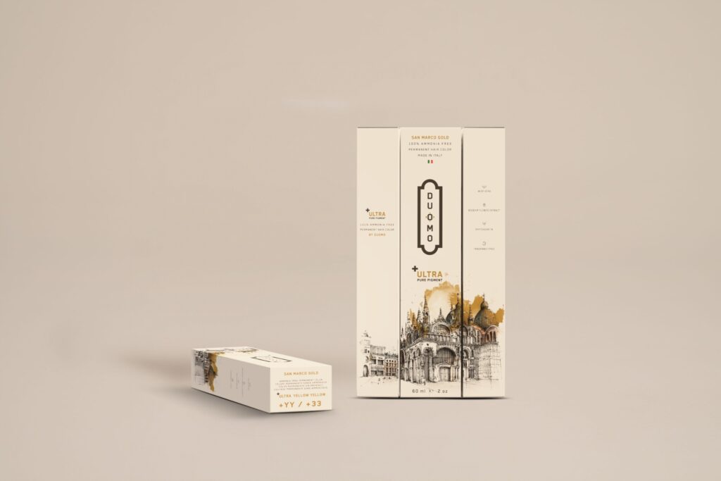 Duomo YY+ Ultra Yellow Yellow hair color tube and boxes on a beige backdrop